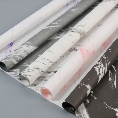 Un buon prezzo. Il produttore vende all'ingrosso bouquet di fiori con disegni di marmo bianco per San Valentino, regali in carta da avvolgere e regali in confezione fai da te per i negozi di fiori in linea