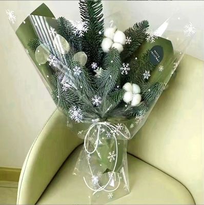 Un buon prezzo. Fioraio di cellophane a fiocchi di neve impermeabili per Natale, bouquet di fiori per la vigilia di Natale, regali, fabbrica di imballaggi di mele all'ingrosso e vendita diretta in linea